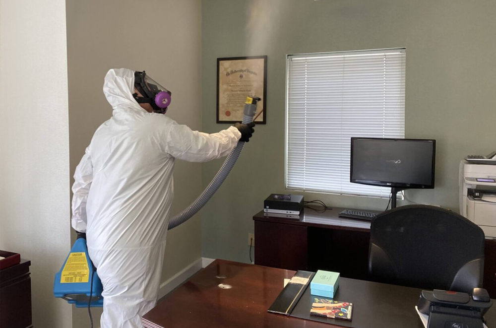 tech spraying a room